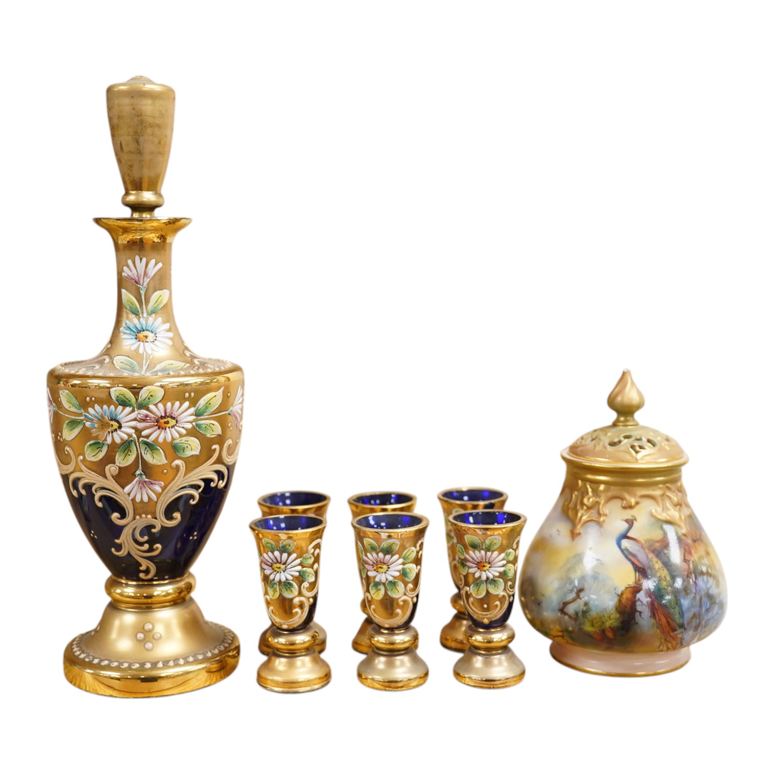 A Royal Worcester peacock painted jar and cover and a Bohemian blue glass decanter and six glasses, with gilt and enamel decoration, decanter 26cm high including stopper. Condition - finial to Worcester pot cover chipped